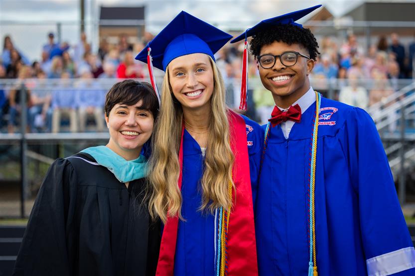 Students in blue robes graduate